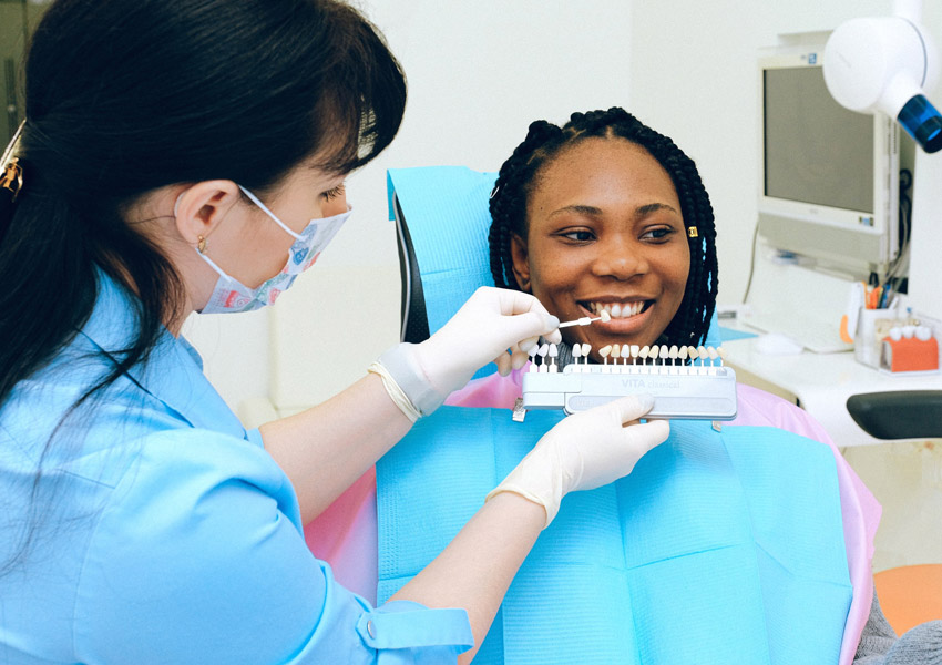 Dentist office with dental assistant and a female black patient
